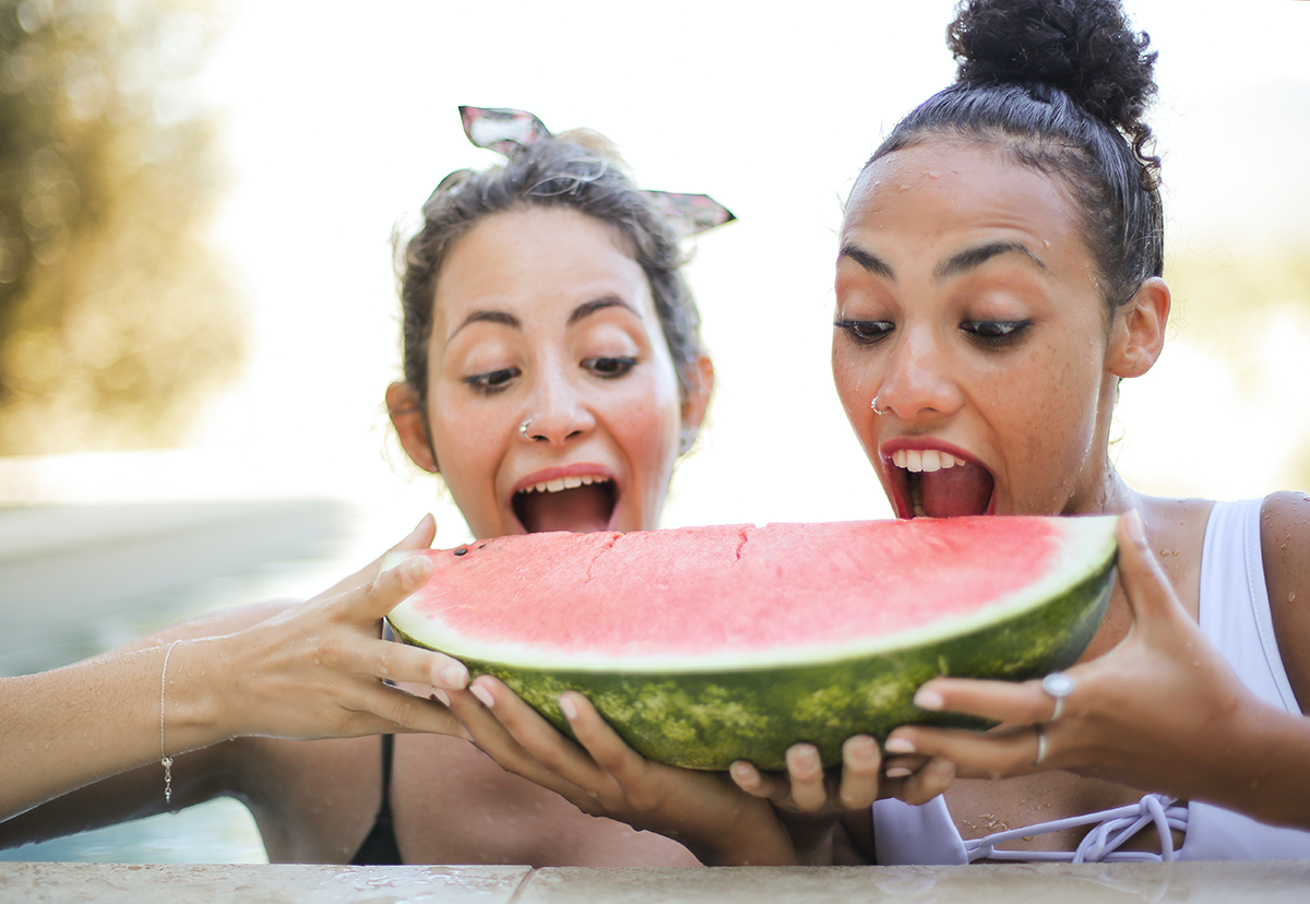 two people sharing a slice of watermelon