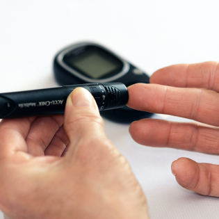 photo of a person pricking their finger to test blood sugar
