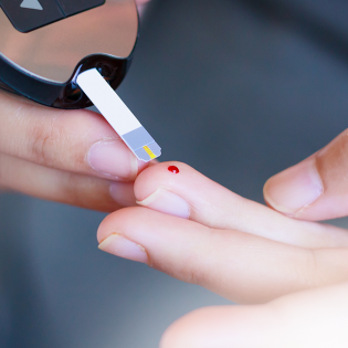 Photo of a finger being pricked to test blood sugar